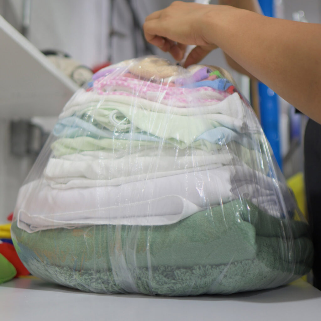 Neatly folded laundry wrapped and packaged by Sudsies wash and fold service