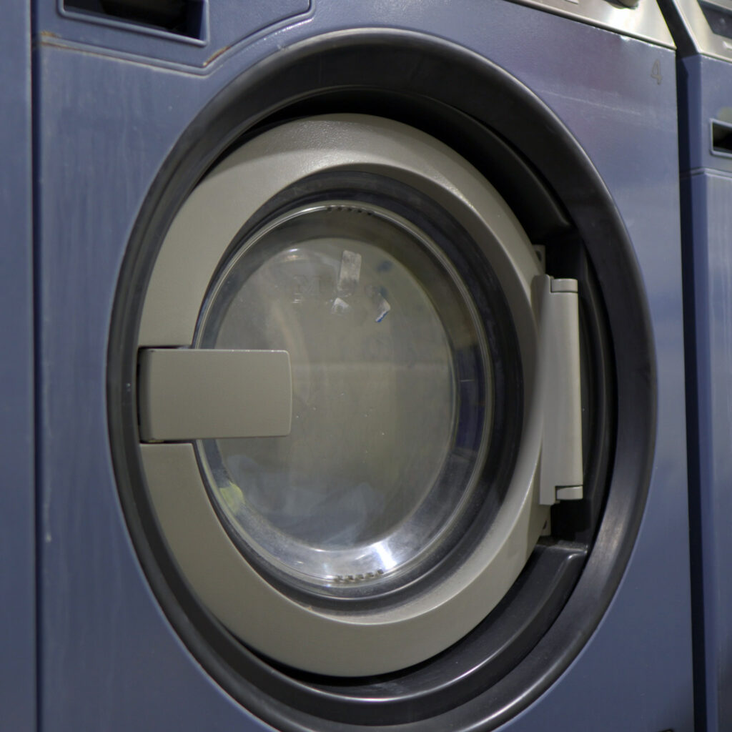 Professional commercial washing machine used in Sudsies garment cleaning process
